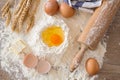 Top view eggs, dough, flour and rolling-pin on wooden table Royalty Free Stock Photo