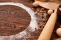 Top view eggs, dough, flour and rolling-pin on wooden table Royalty Free Stock Photo