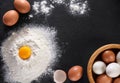 Top view eggs and flour on the background of a slate board.