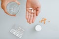 Top view elderly woman holding pharmaceutical capsules of medicines and glass of water. Royalty Free Stock Photo