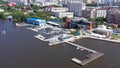 Top view of embankment with sailing yachts on background of city. Video. Beautiful panorama of large city near coast