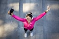 Top view of emotional female jogger holding smartphone