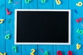 top view of empty blackboard colorful numbers and paper clips on blue wooden