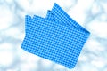 Top view of a empty blue and white checkered kitchen cloth, textile, tablecloth or napkin on blurred abstract light blue white Royalty Free Stock Photo