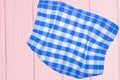 Top view of a empty blue and white checkered kitchen cloth, textile, tablecloth or napkin on blurred light pink wooden background Royalty Free Stock Photo