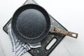 Top view of empty frying pan, striped napkin and black cutting board on the white marble table.Empty space Royalty Free Stock Photo