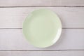 Top view of empty green plate put on white wood table Royalty Free Stock Photo