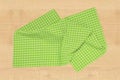 Top view of a empty green and white checkered kitchen cloth, textile, tablecloth or napkin on blurred light wooden background. Royalty Free Stock Photo