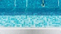 Top view of empty pool with hydro massage in swimming pool with blue mosaic tiles and drain bars. Transparent calm pool water back Royalty Free Stock Photo