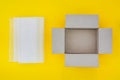 Top view of empty open brown paper cardboard box and translucent white plastic bubble wrap  on yellow background Royalty Free Stock Photo