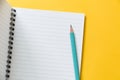 Top view of empty open lined notebook with blue color pencil on yellow background with copy space, flat lay Royalty Free Stock Photo