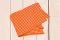 Top view of a empty orange yellow and white checkered kitchen cloth, textile, tablecloth or napkin on blurred light wooden Royalty Free Stock Photo