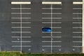Top view on an empty parking lots with one blue car. Aerial view of car park. Royalty Free Stock Photo