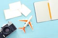 Top view of empty photographs frame next to airplane, camera and blank notebook over wooden table. traveling concept. ready to Royalty Free Stock Photo