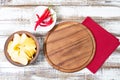 Top view - empty pizza desk board on wood table with chili pepper and potato chips, mock up Royalty Free Stock Photo