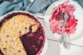 Top view of an empty plate with forks on it after pie. part of a crumble berry pie has been eaten. wooden table, close