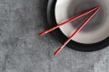 Empty ceramic plate and red chopsticks. Japanese cuisine Royalty Free Stock Photo