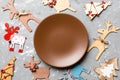 Top view of empty plate and New Year decorations on cement background. New year serving for festive dinner. Reindeer and Christmas Royalty Free Stock Photo