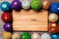 Top view of empty plate surrounded with colorful baubles on wooden background. New Year decorations. Christmas Eve concept Royalty Free Stock Photo