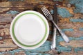 Top view of empty plate and vintage cutlery on wooden board Royalty Free Stock Photo