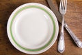 Top view of empty plate and vintage cutlery on wooden board Royalty Free Stock Photo