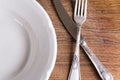 Top view of empty plate and vintage cutlery on wooden board Royalty Free Stock Photo