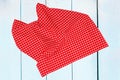 Top view of a empty red and white checkered kitchen cloth, textile, tablecloth or napkin on blurred light blue wooden background. Royalty Free Stock Photo