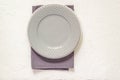 Top view of empty served plates, gray textile napkin on white background. Copy space