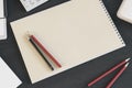 Top view of empty spiral notepad on dark wooden desktop with keyboard and pencils. Drawing, workplace, supplies and art concept. Royalty Free Stock Photo