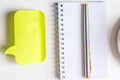 Top view of empty spiral notepad, silver pen, yellow sticker and cup of coffee on white background. Business or education concept Royalty Free Stock Photo