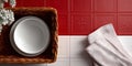 Top view of empty white ceramic bowls in wicker basket with white flowers and folded kitchen towel on red and white tiled surface Royalty Free Stock Photo