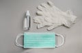 Top view of Epidemic Protective kit, Masks pile, gloves and alcohol hand sanitizer bottle on gray color background