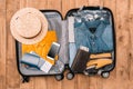Top view of essentials for tourist with clothes, accessories and gadgets, wallet, passport, smartphone in bag. Royalty Free Stock Photo