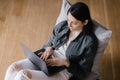 top view, European business woman in a gray shirt and white jeans sitting in a chair, working with a laptop and chatting Royalty Free Stock Photo