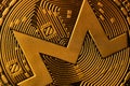 Extreme macro closeup of crypto Monero golden coin logo