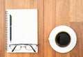 Eyeglasse and notepad with coffee cup on wood deck