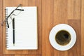 Eyeglasse and notepad with coffee cup on wood deck