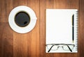 Eyeglasse and notepad with coffee cup on wood deck