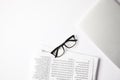 top view of eyeglasses, laptop and newspapers on white table Royalty Free Stock Photo