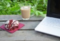 Top view of female using her laptop at a cafe. Overhead shot of young woman sitting at a table with a cup of coffee and mobile pho Royalty Free Stock Photo