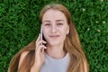 Top view face of teenage girl talking on mobile phone lying on green grass Royalty Free Stock Photo