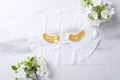Top view of facial mask and golden luxury eye patches, blossom branches on white marble surface Royalty Free Stock Photo