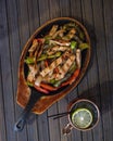 Top view of a Fajita dish and Moscow mule drink on a wooden surface