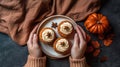 Top view of fall shaped pumpkin spice cakes and hands holding latte. Generative AI Royalty Free Stock Photo