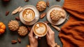 Top view of fall shaped pumpkin spice cakes and hands holding latte. Generative AI Royalty Free Stock Photo