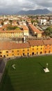 Top view of a fallen marble angel on the lawn and the beautiful historic city of Pisa, Tuscany in the background on a sunny day