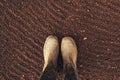 Top view of farmer rubber boots on ploughed arable land