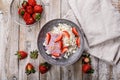 Top view farmers delicious cottage cheese with slices of ripe strawberries. Breakfast ideas: dairy products and juicy fruits.