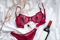 Top view fashion red lace lingerie with bootle of red wine and perfume. Set of woman essential accessory and underwear