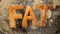 TOP VIEW: FAT letters fry in oil in a grill - boils and dirty